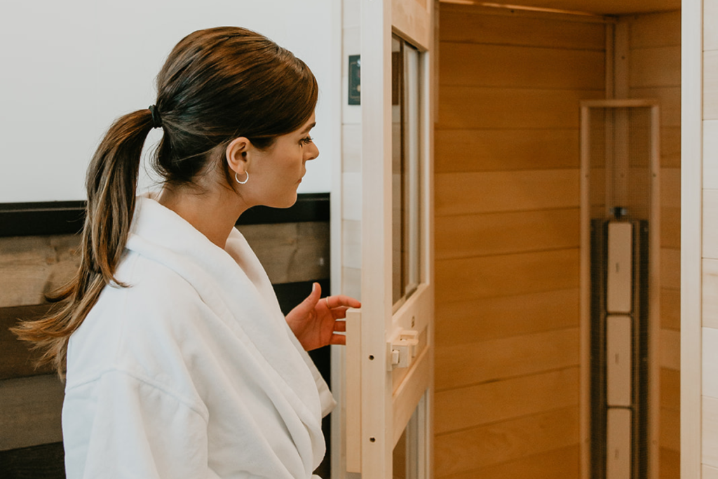 A woman going into an infrared sauna after a work to help increase blood flow, circulation, and decrease inflammation to help muscle recovery.