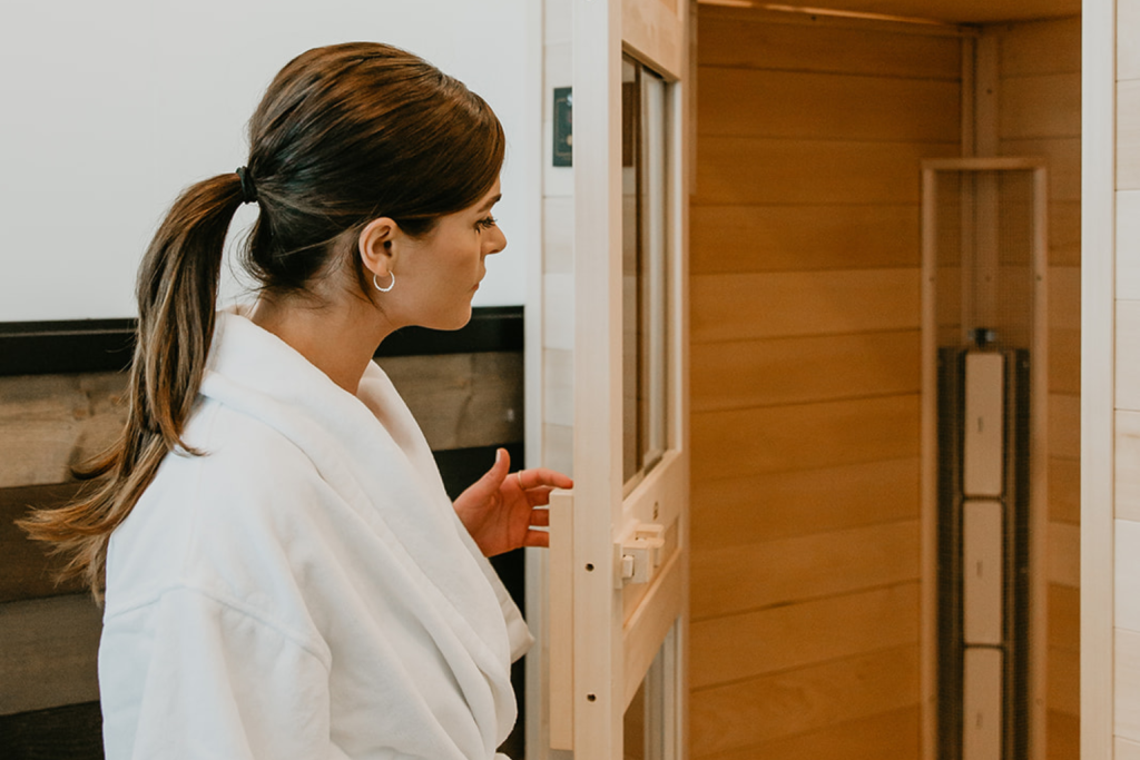 A woman going into an infrared sauna to help increase blood flow, circulation, and decrease inflammation 