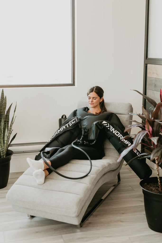 A woman relaxing during NormaTec compression therapy to help speed up the recovery process.