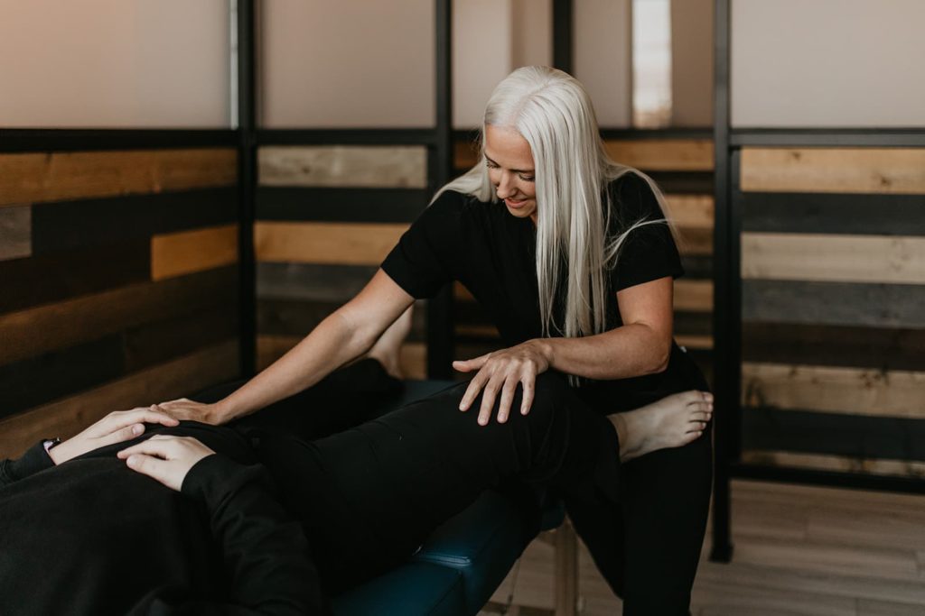 A fascial stretch therapist helping to increase mobility and decrease pain for a patient experiencing tight hip flexors and lower back pain