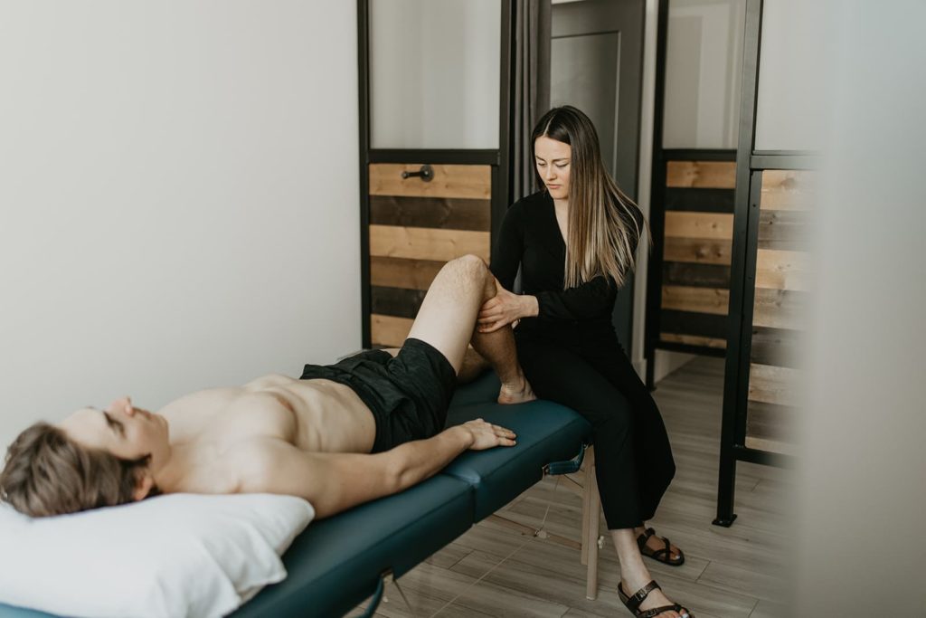 A physiotherapist providing a physiotherapy treatment for a patient needing sport recovery in order to speed up muscle recovery.