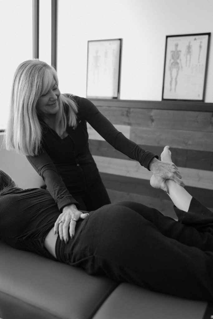 A fascial stretch therapist performing a fascial stretch treatment on a client to improve muscle recovery.