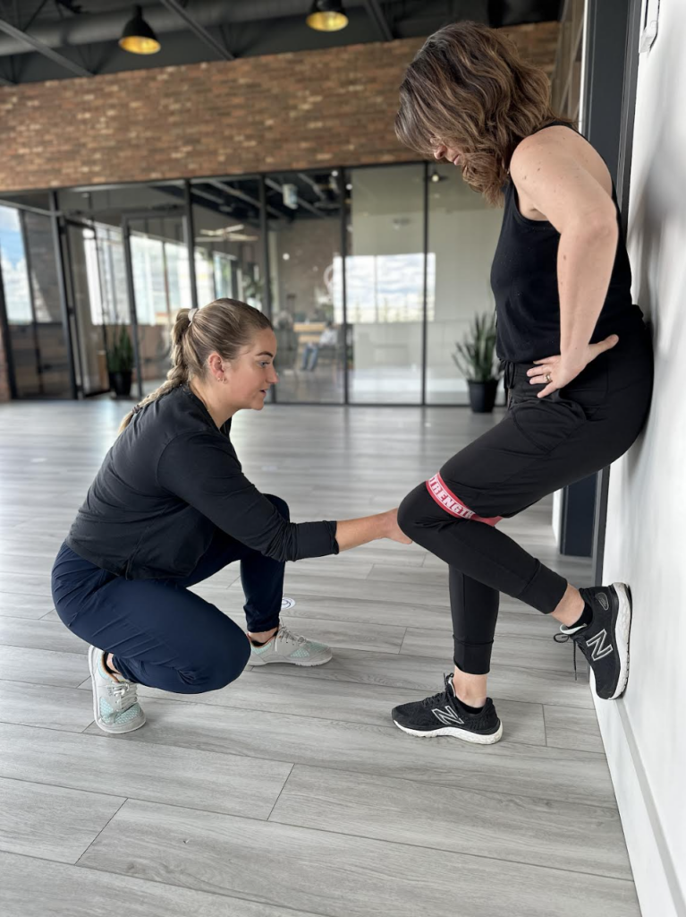 A physiotherapist helping patient with physiotherapy by adjusting band