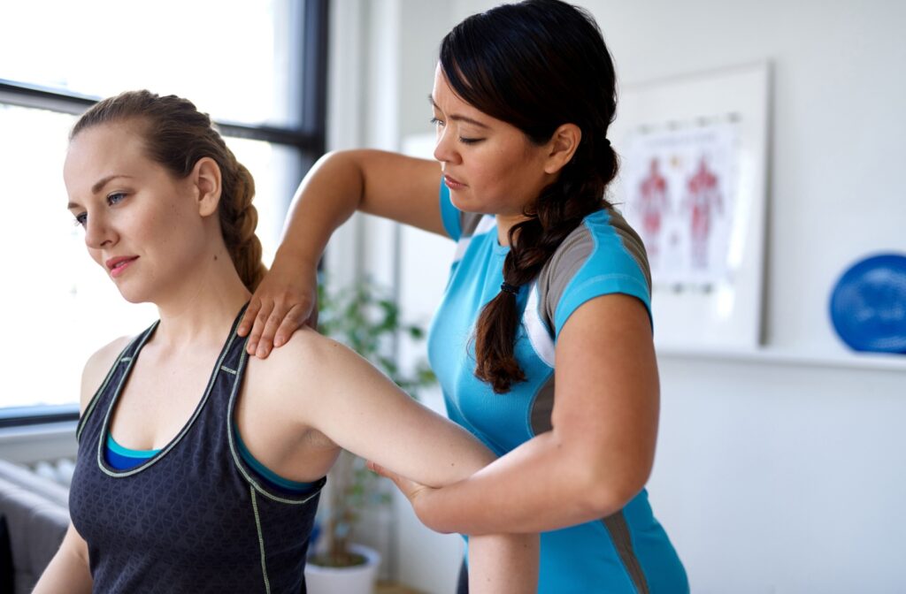 Physiotherapist performing manual therapy on a patient's shoulder during a treatment session.