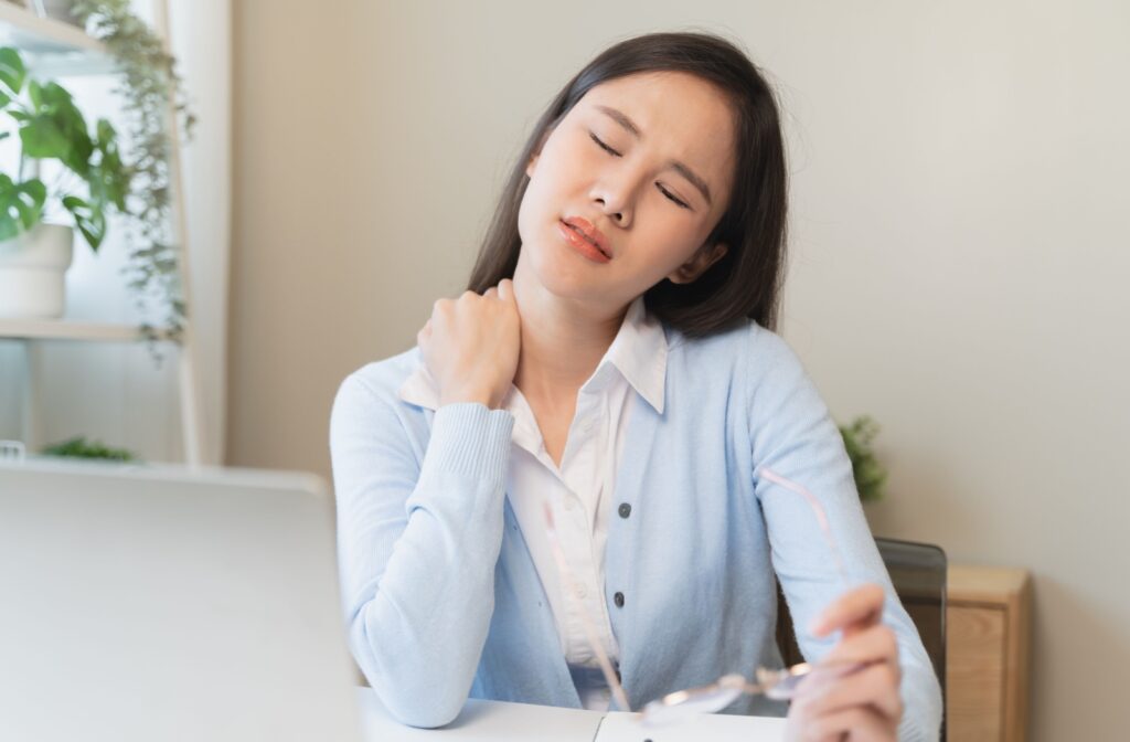 Woman craddling her neck to relieve the soreness she is feeling
