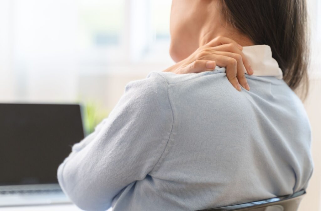 Close up of a hand rubbing neck to relieve neck tension and soreness.