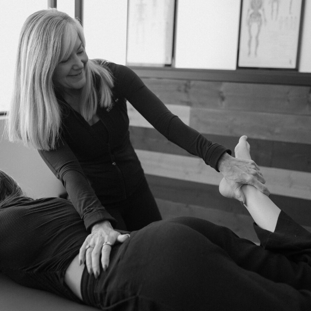 A licensed professional helps a client stretch their leg