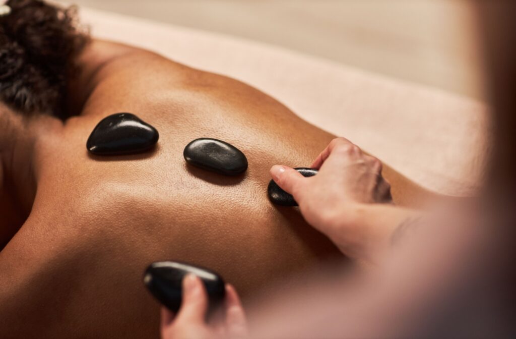 Hot stones being placed on a persons spine during a massage treatment.