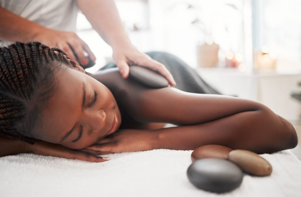 A person laying on their stomach while they receive a hot stone massage